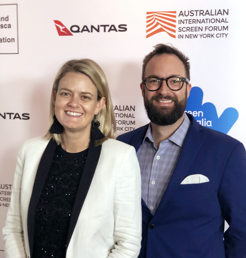 Co-Directors Miranda and Khrob Edmonds standing in front of a media wall at the 2019 Australian International Screen Forum in New York City.